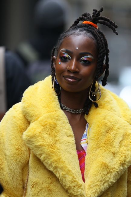 A stylish woman wearing a colorful fur coat, showcasing street fashion in NYC.