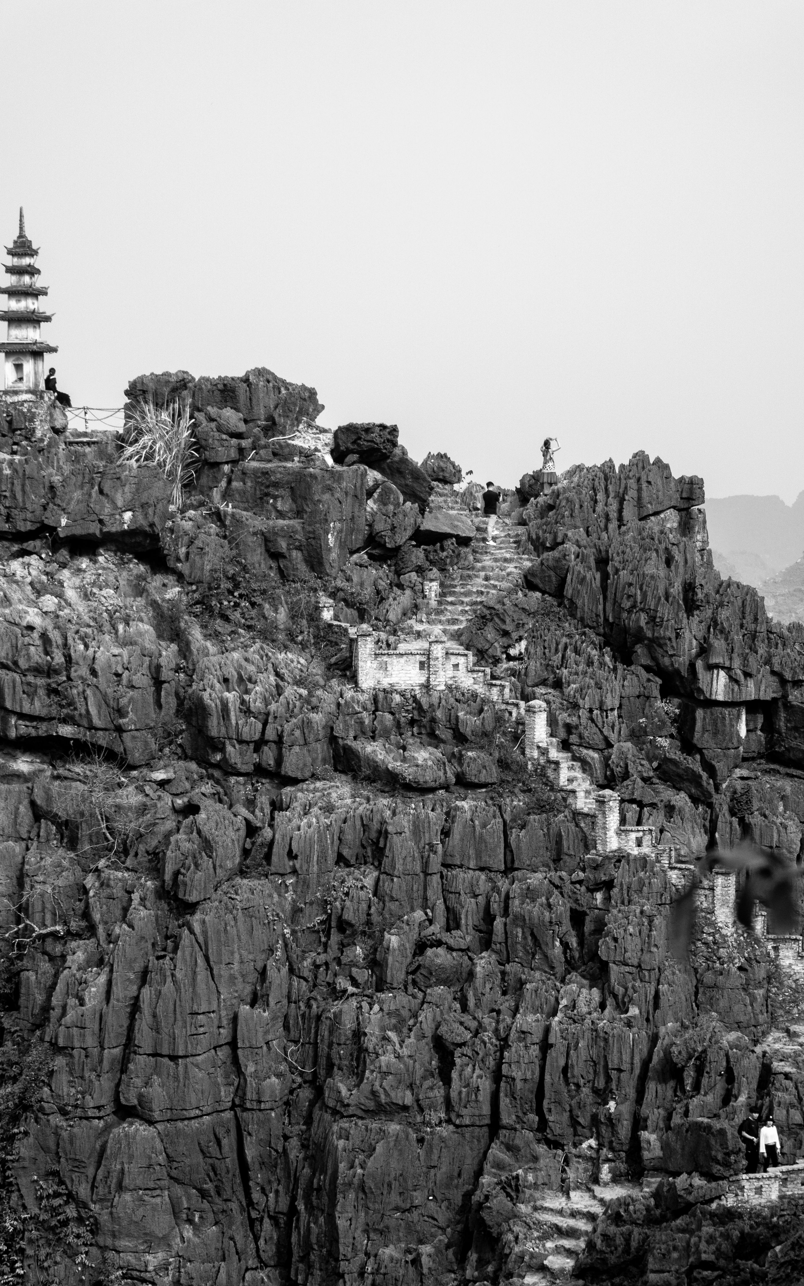 Explore breathtaking rugged rock formations with ancient pagoda in black and white.