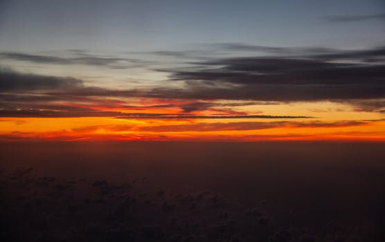 黑暗的地平线上，天空被鲜艳的橙红两色渲染，日落景象令人惊叹