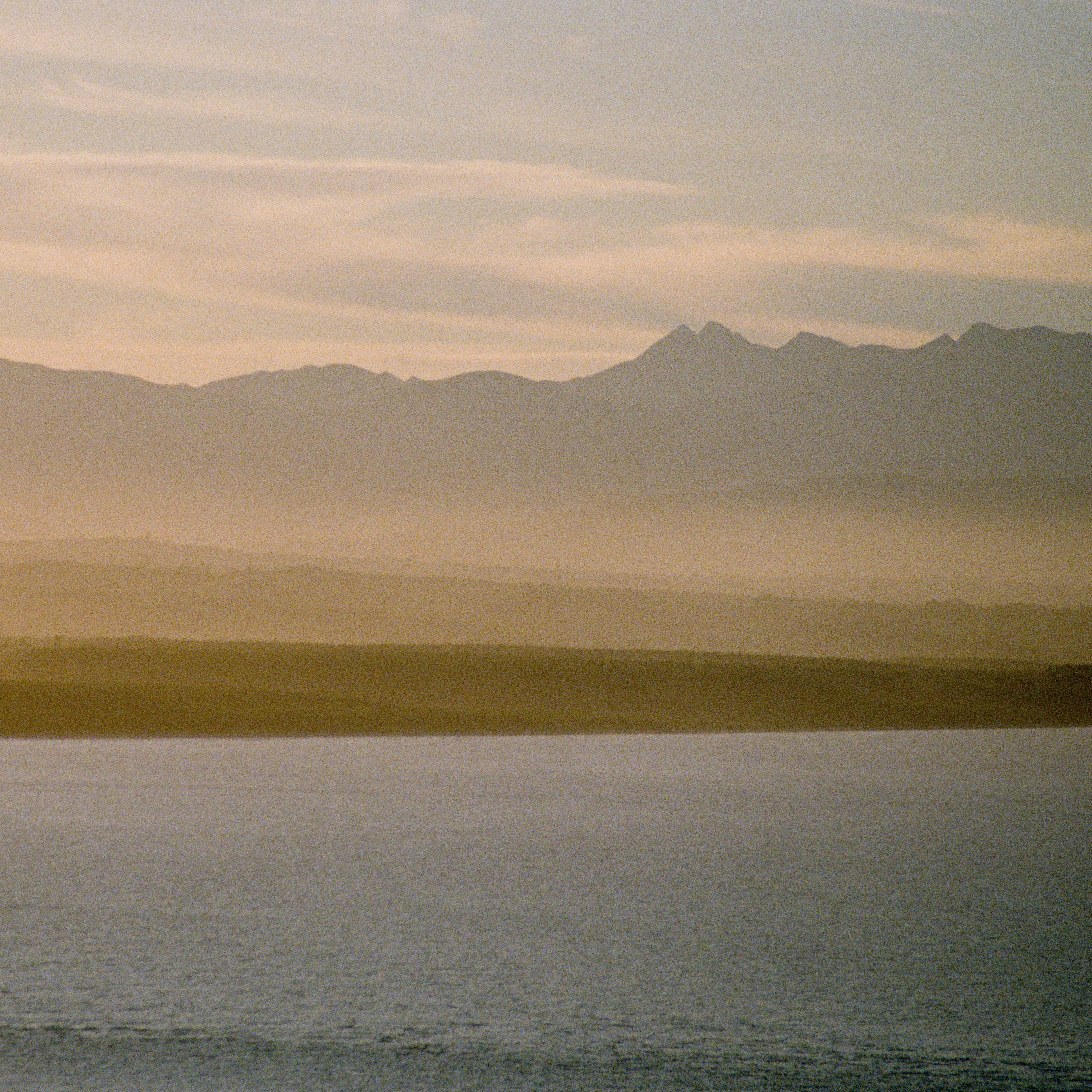 Film Photo of a Body of Water and Mountains at Sunset
