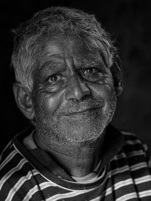 Free Close-up black and white portrait of a smiling elderly man with short hair. Stock Photo