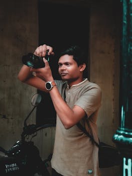 Portrait of a young male photographer taking pictures in Ahmedabad, India, showcasing local urban life.