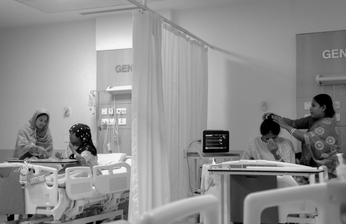Women caring for patients in a Kolkata hospital room