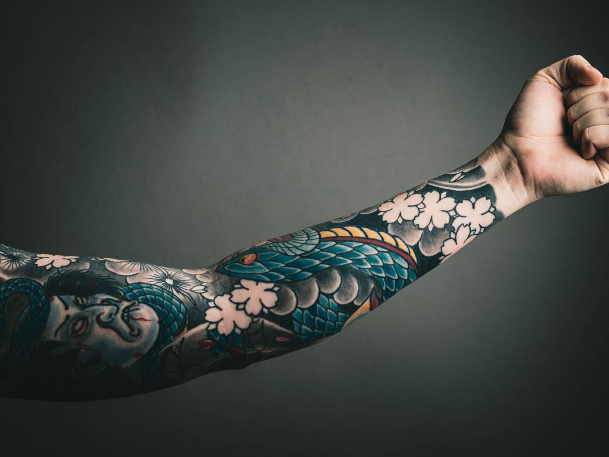 A finished full blackwork sleeve photographed in daylight.
