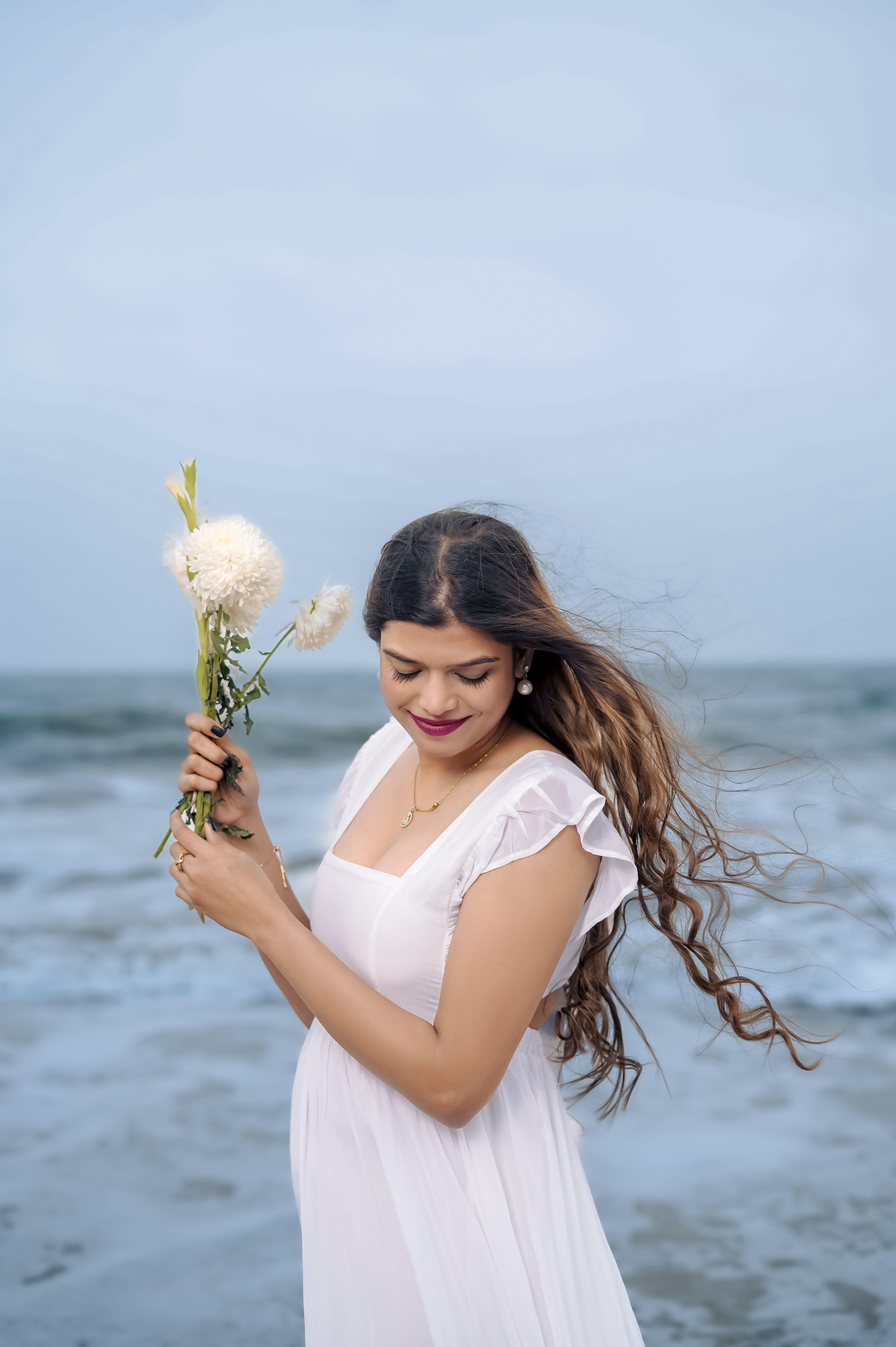 Young Woman in a White Dress Holding Flowers on a Shore Free Stock Photo Young Woman in a White Dress Holding Flowers on a Shore Free Stock Photo