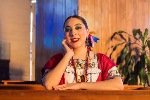 Free Portrait of smiling woman in vibrant traditional clothing indoors. Stock Photo