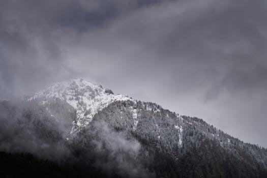 A stunning view of snowcapped mountains amidst clouds in Habach, Austria.