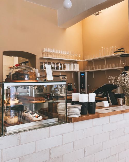 Free Warm and inviting café interior in Vilnius showcasing a patisserie counter with various baked goods. Stock Photo