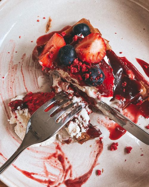 Free Close-up of a sweet dessert slice with strawberries and blueberries on a plate. Stock Photo