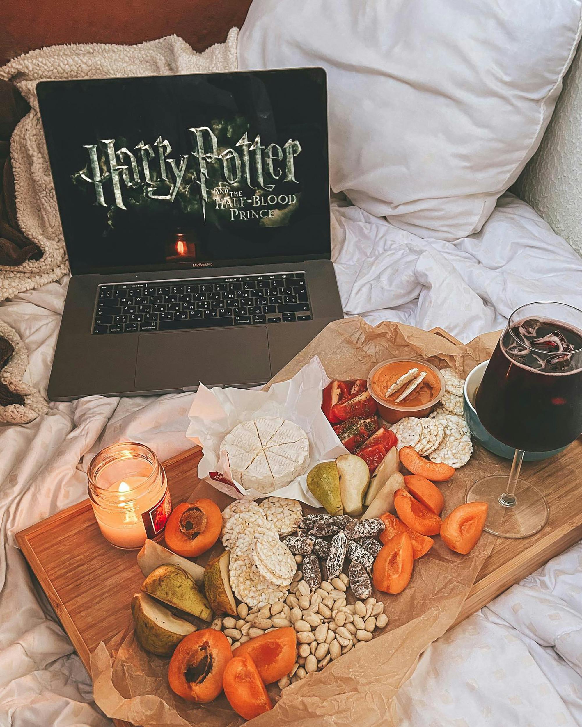 food and drink on wooden tray prepared for watching harry potter movie on bed