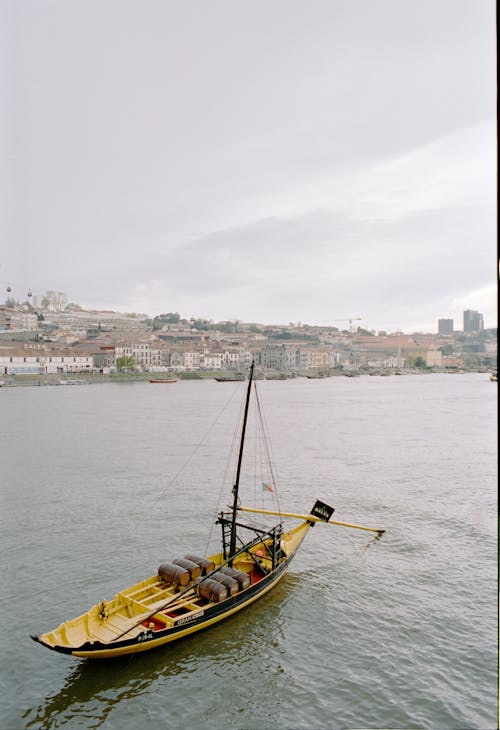 A boat is floating in the water near a city