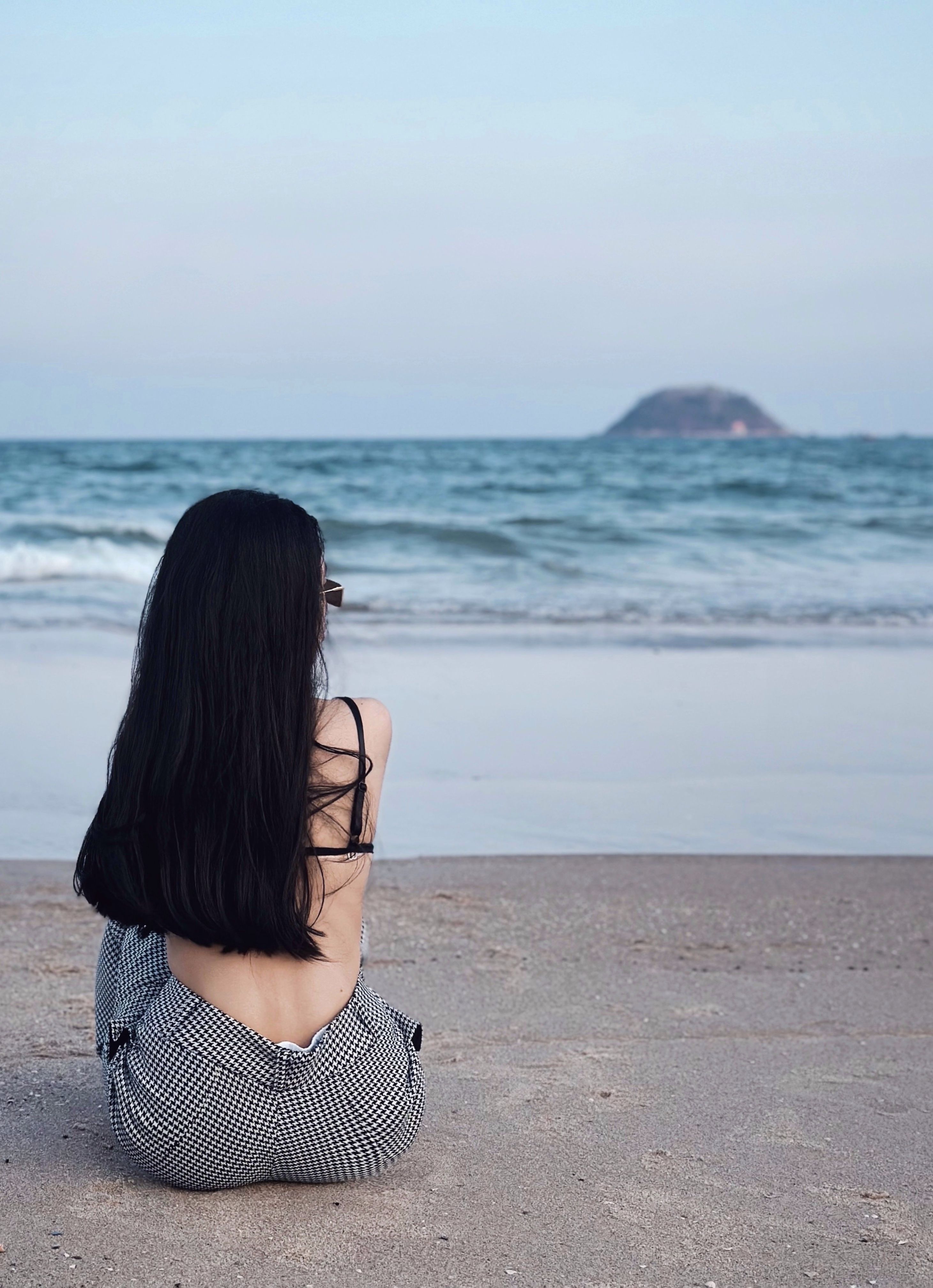 Back View of a Woman in a Bikini Sitting on the Beach · Free Stock Photo
