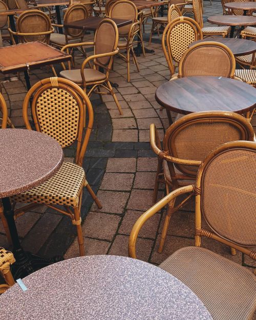 Free Charming outdoor cafe seating with wicker chairs and tables in Vilnius, Lithuania. Stock Photo