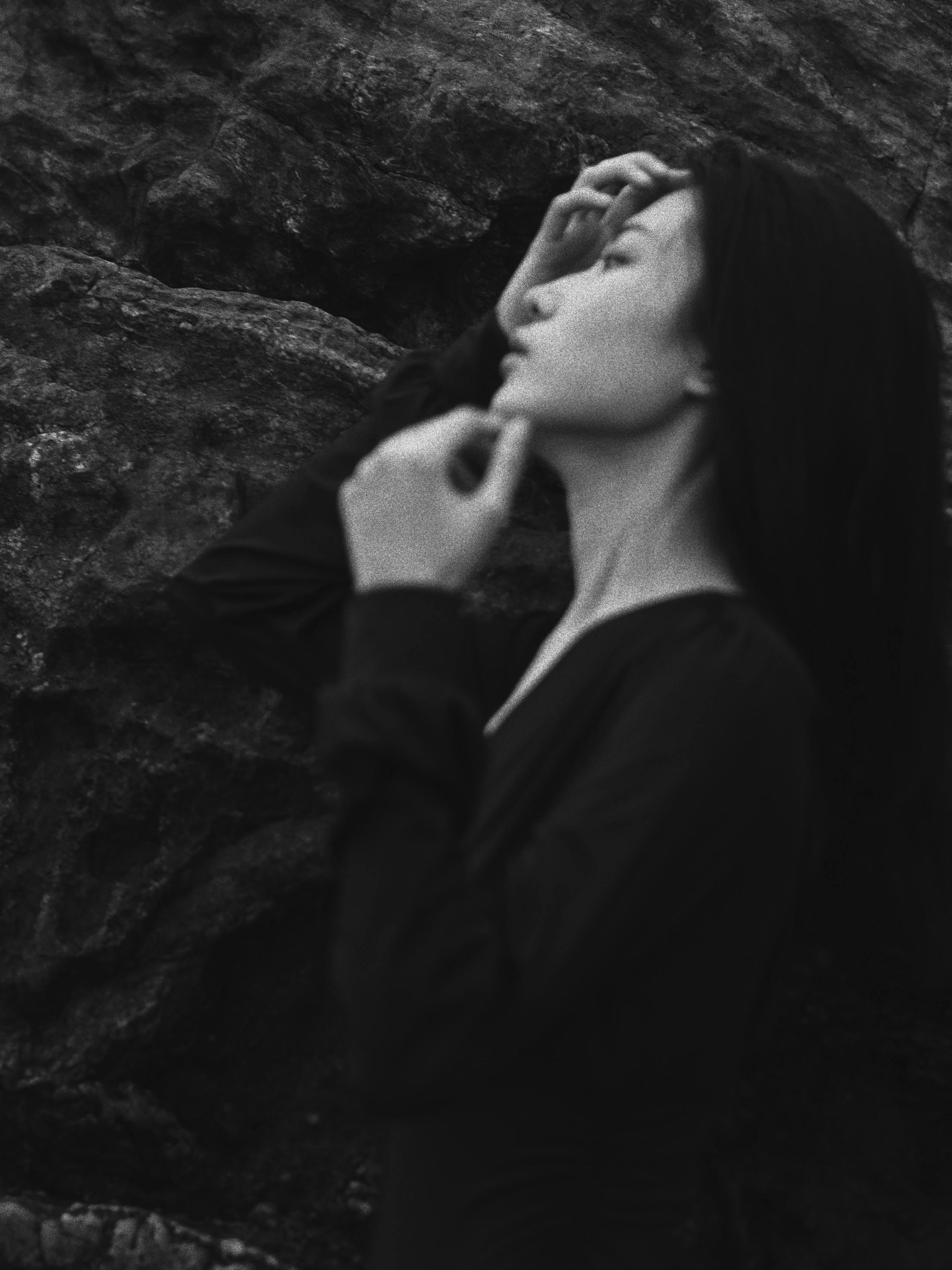 Elegant black and white portrait of a woman outdoors, showcasing artistic expression.