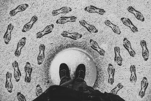 A person standing in the middle of a circle of footprints