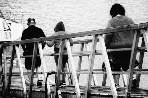 免费 3人在桥黑白照片上行走 素材图片