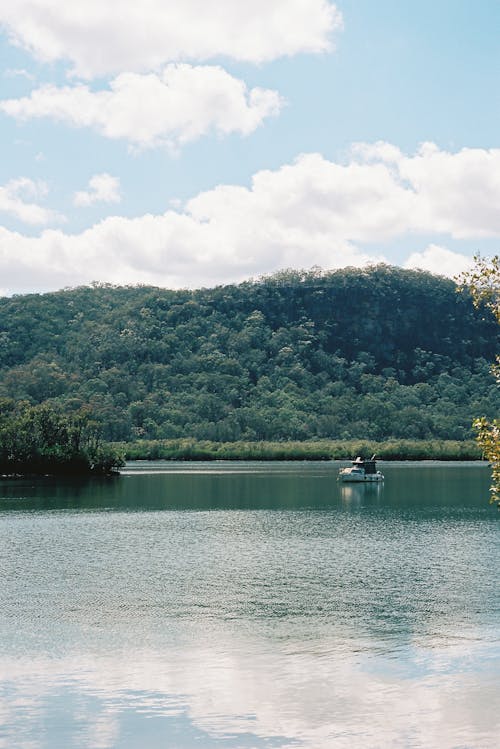 A boat is floating in the water near a mountain