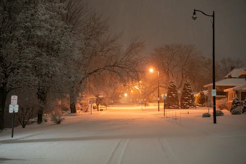 A street is covered in snow at night