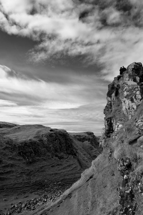 Black and white photo of a cliff with clouds