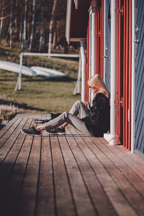 Photo Of Woman Sitting On A Wooden Surface