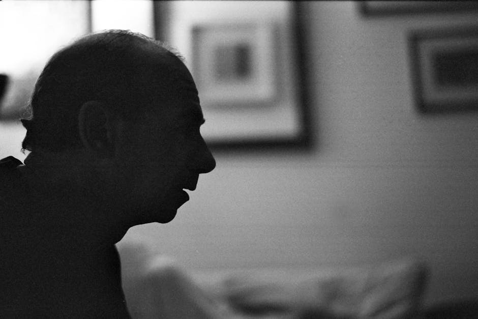 Artistic profile silhouette of a man in a room, captured in black and white.
