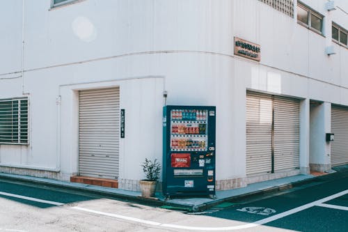 A vending machine is parked in front of a building