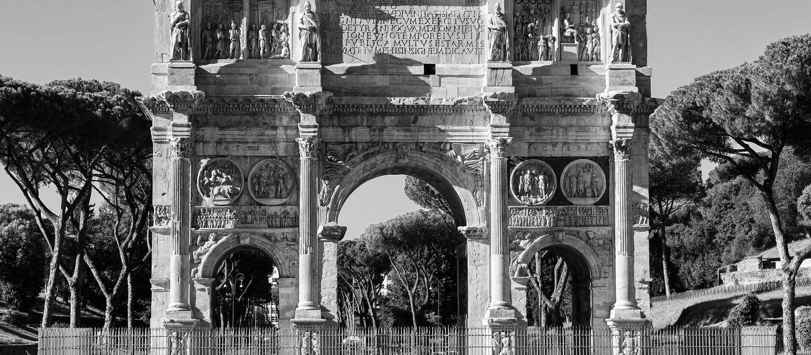 The majestic Arch of Constantine in Rome, Italy, captured in striking black and white.