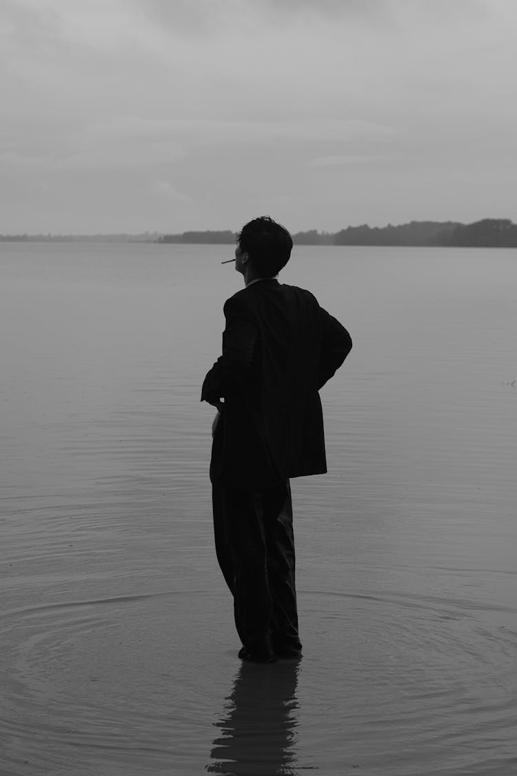 Black And White Photography Of A Silhouette Of A Person Standing In The Sea