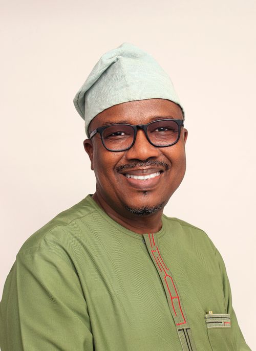 Free Studio portrait of a smiling African man wearing traditional green clothing and glasses, showcasing cultural elegance. Stock Photo