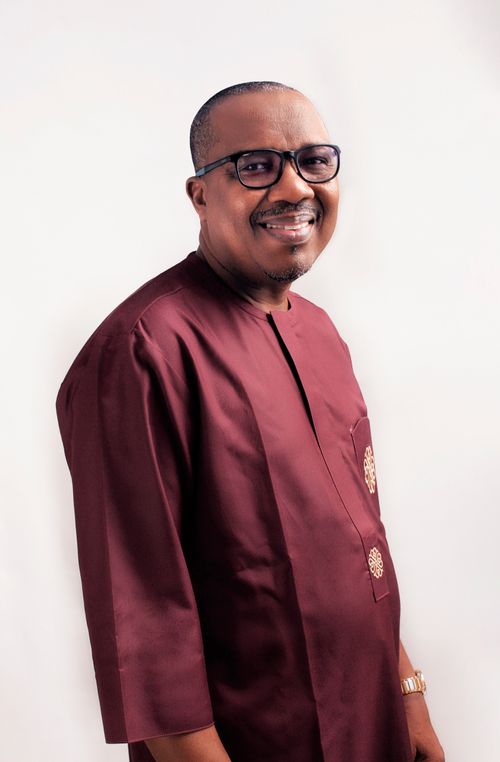 Free Portrait of a smiling African man in traditional attire with a white studio background. Stock Photo