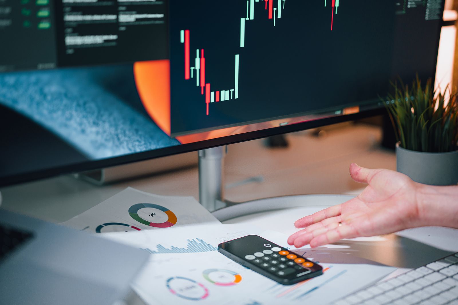 Free Businessman analyzing stock market data on computer monitor with documents and calculator. Stock Photo