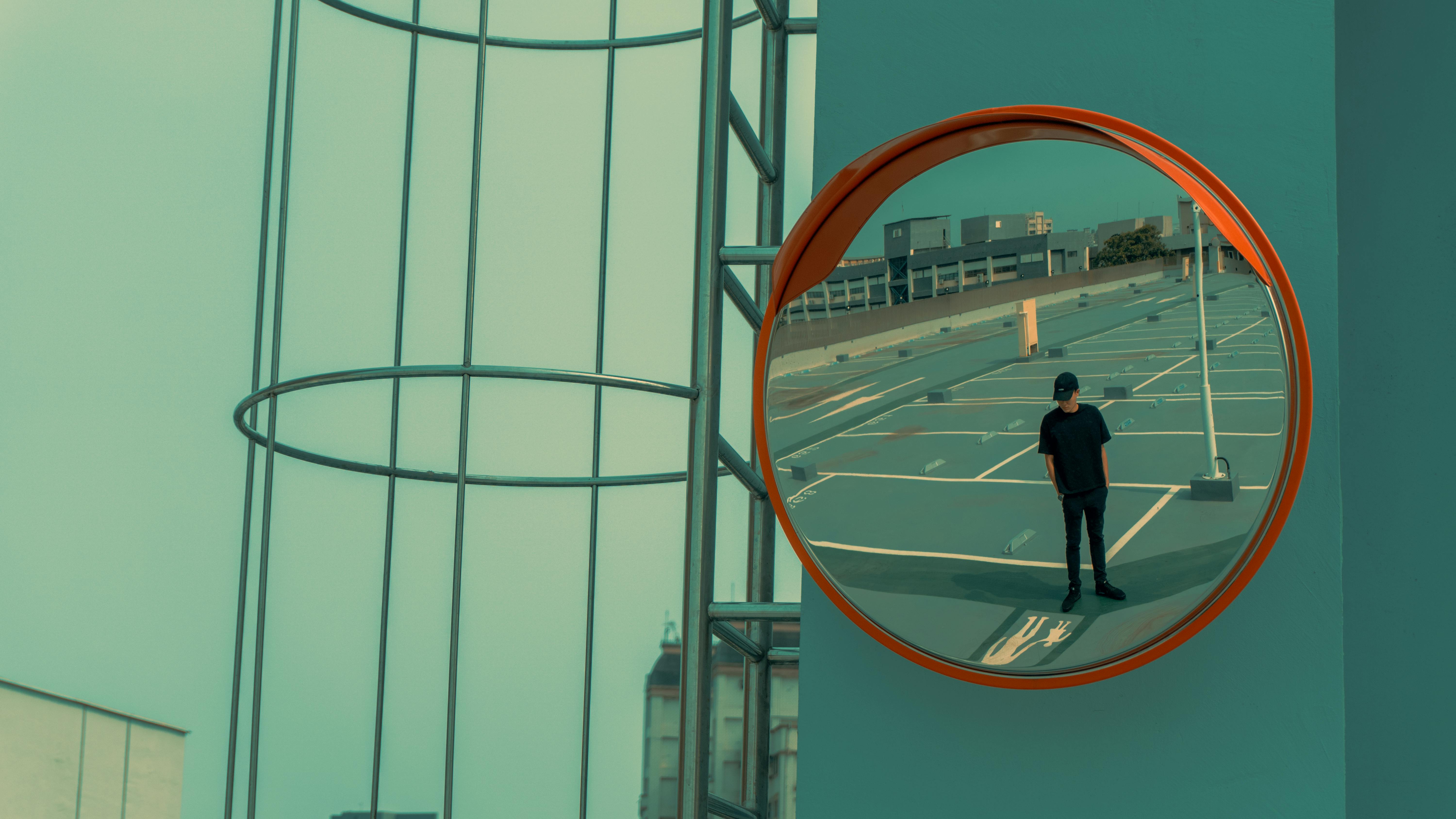 Reflection in Mirror of Man Standing on Parking Lot