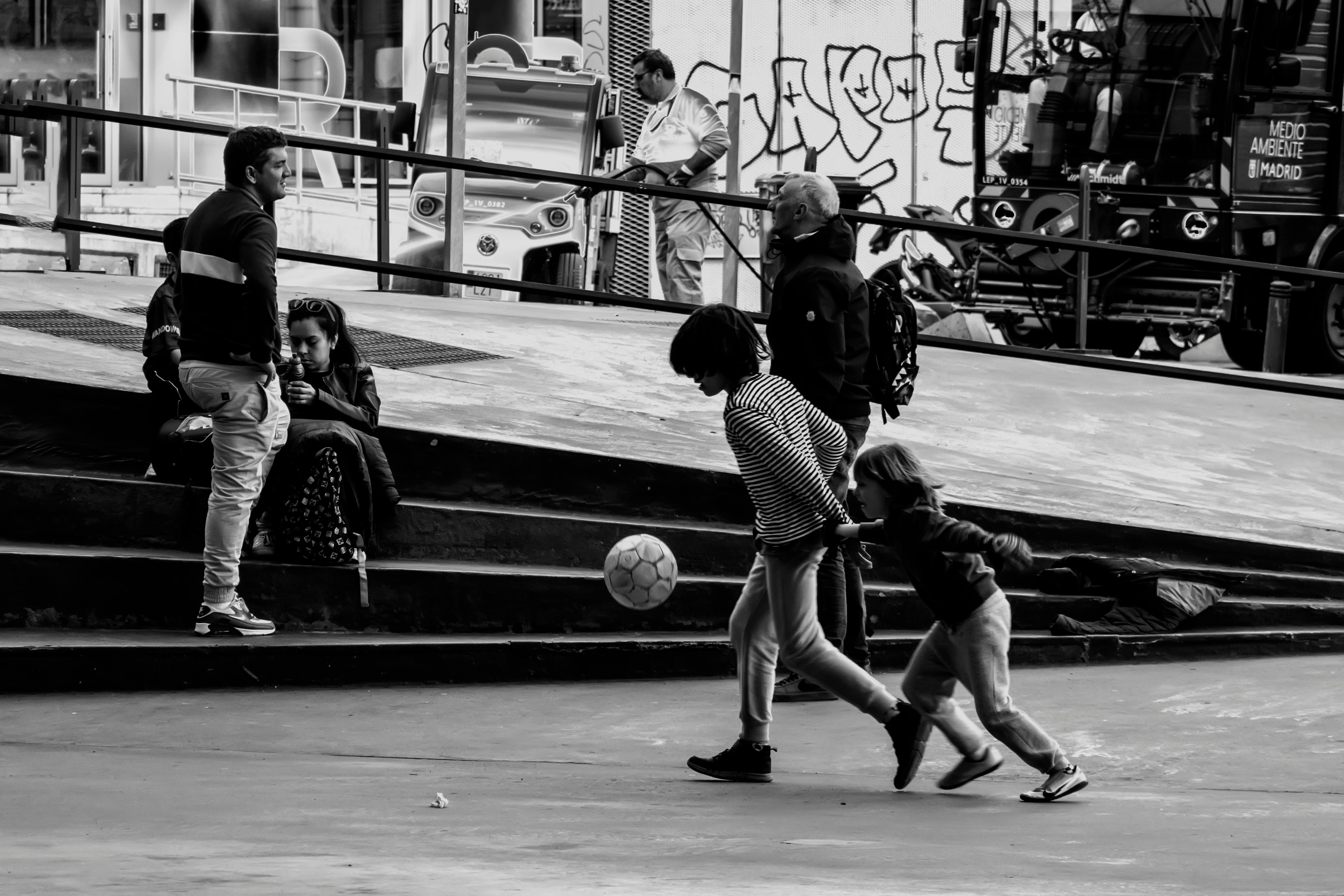 children playing ball on concrete in city