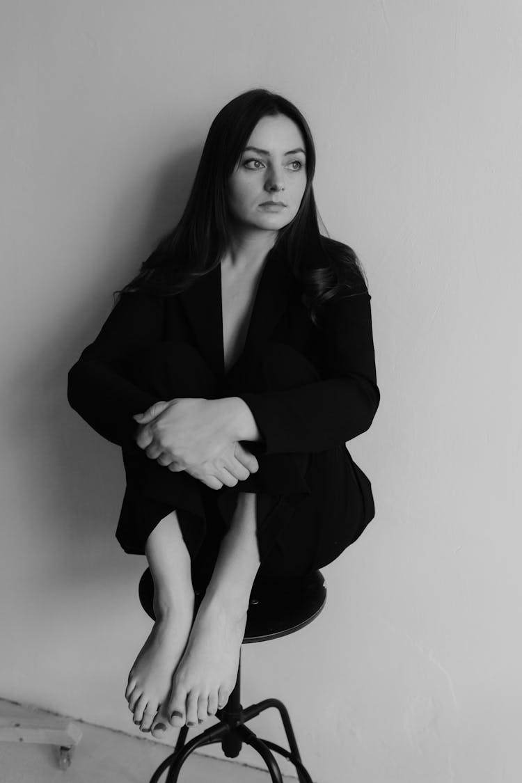 Beautiful Woman In Jacket Sitting On Stool