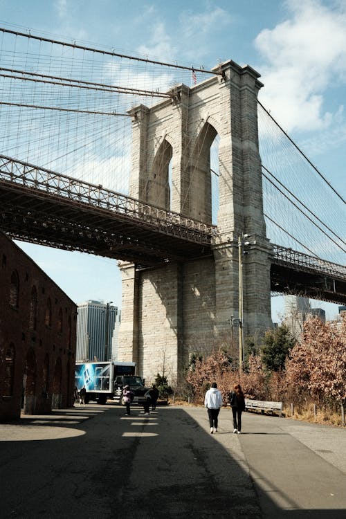 People walking under the brooklyn bridge