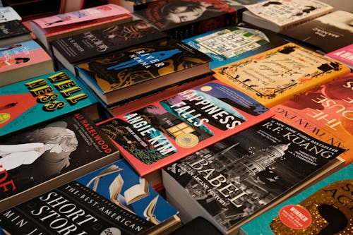 A pile of books on a table with a large pile of books