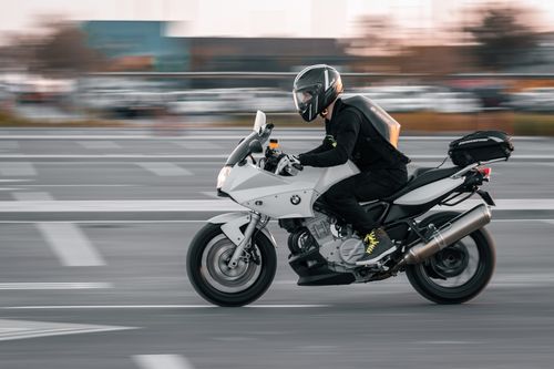 Free A motorcyclist speeding on a road in Abu Dhabi, capturing motion and excitement. Stock Photo