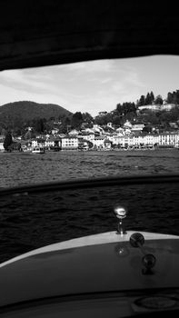 Black and white view of a coastal town from a watercraft, showcasing serene seaside architecture.
