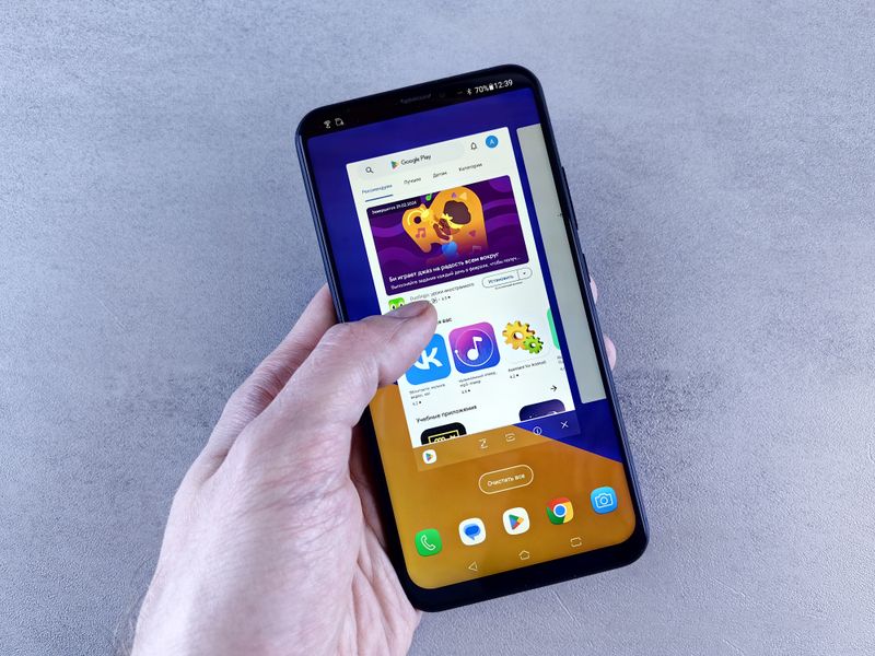 Hand holding a smartphone showing an app store download screen