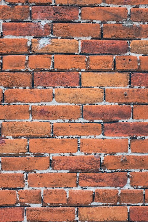 A brick wall with a red brick pattern