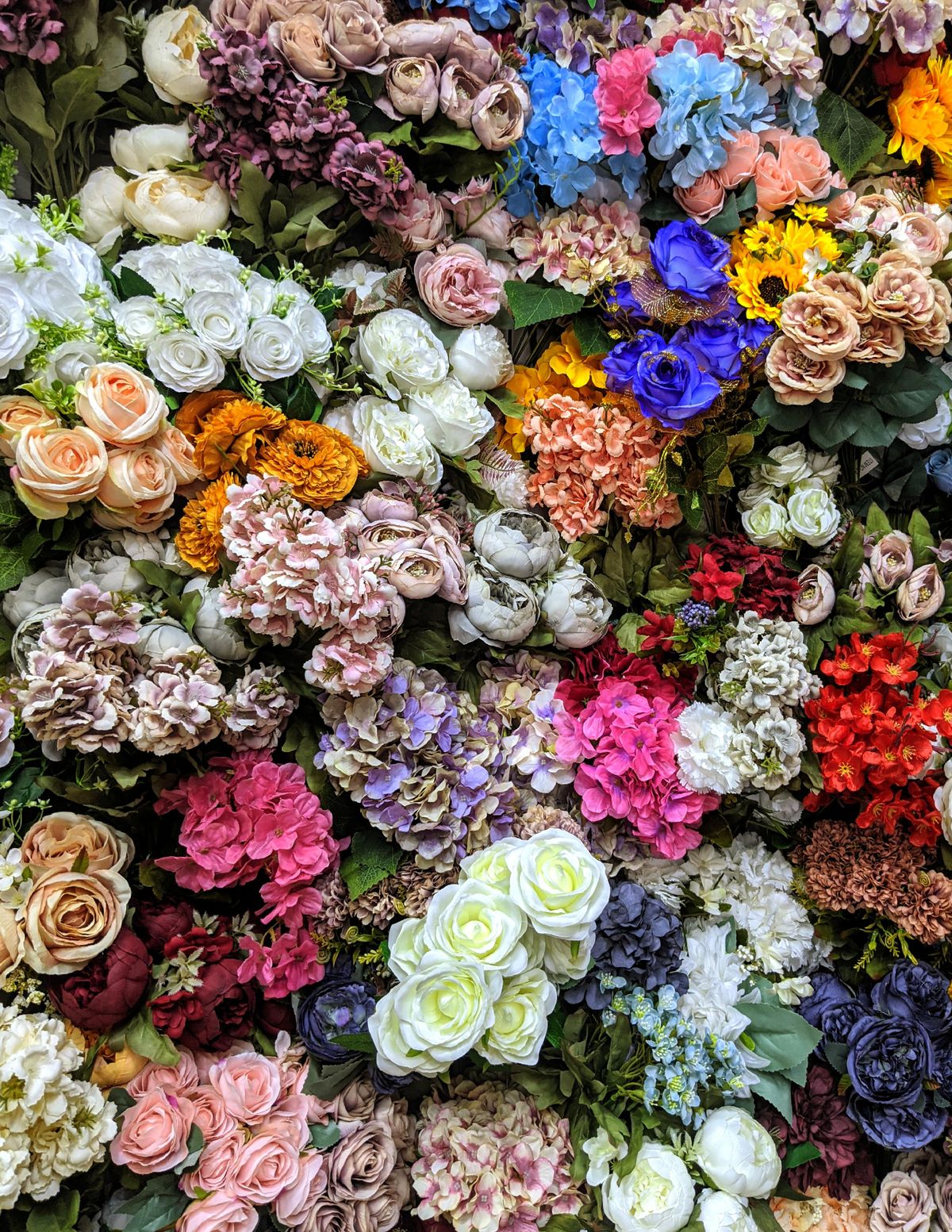 Colourful mixed floral wall with roses and hydrangeas for events