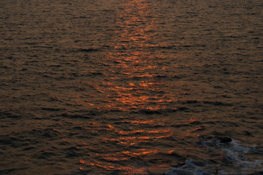 A breathtaking view of ocean waves reflecting the vibrant hues of a sunset.