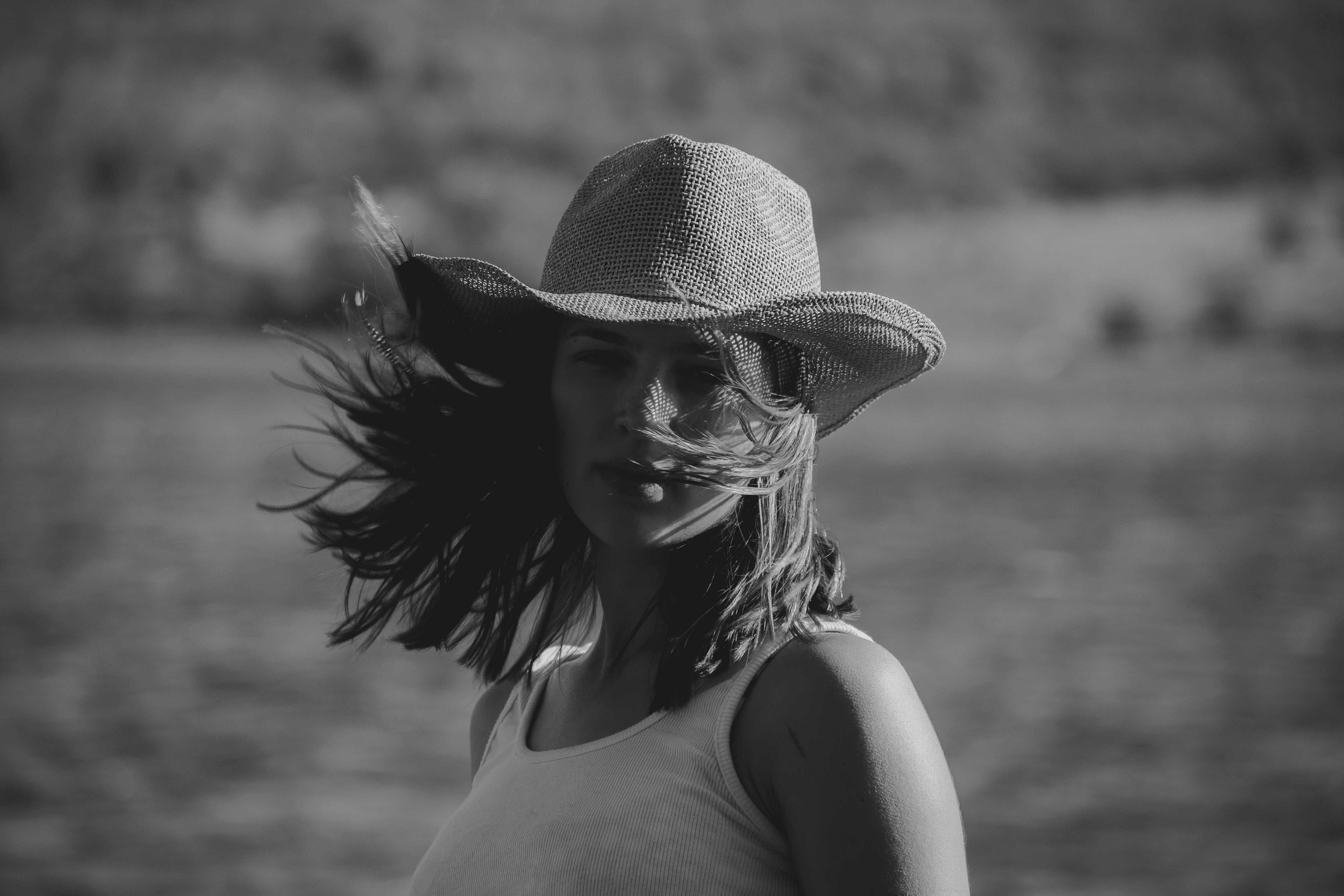 Black and white portrait of a woman wearing a cowboy hat, embodying freedom and style.