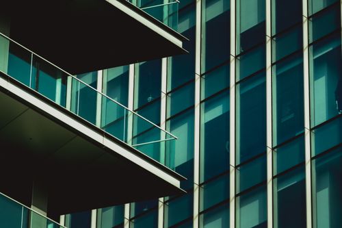 Free Close-up of a modern skyscraper's glass facade featuring balconies in an urban setting. Stock Photo