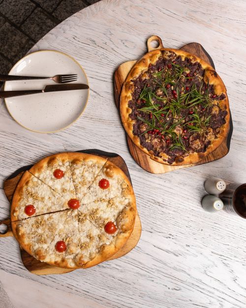 Free Top view of two gourmet pizzas on a wooden table, ready to serve. Stock Photo