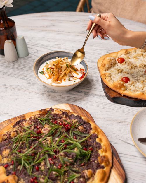 Free A delectable arrangement of gourmet pizzas and soup on a wooden table with artistic presentation for a delicious meal. Stock Photo
