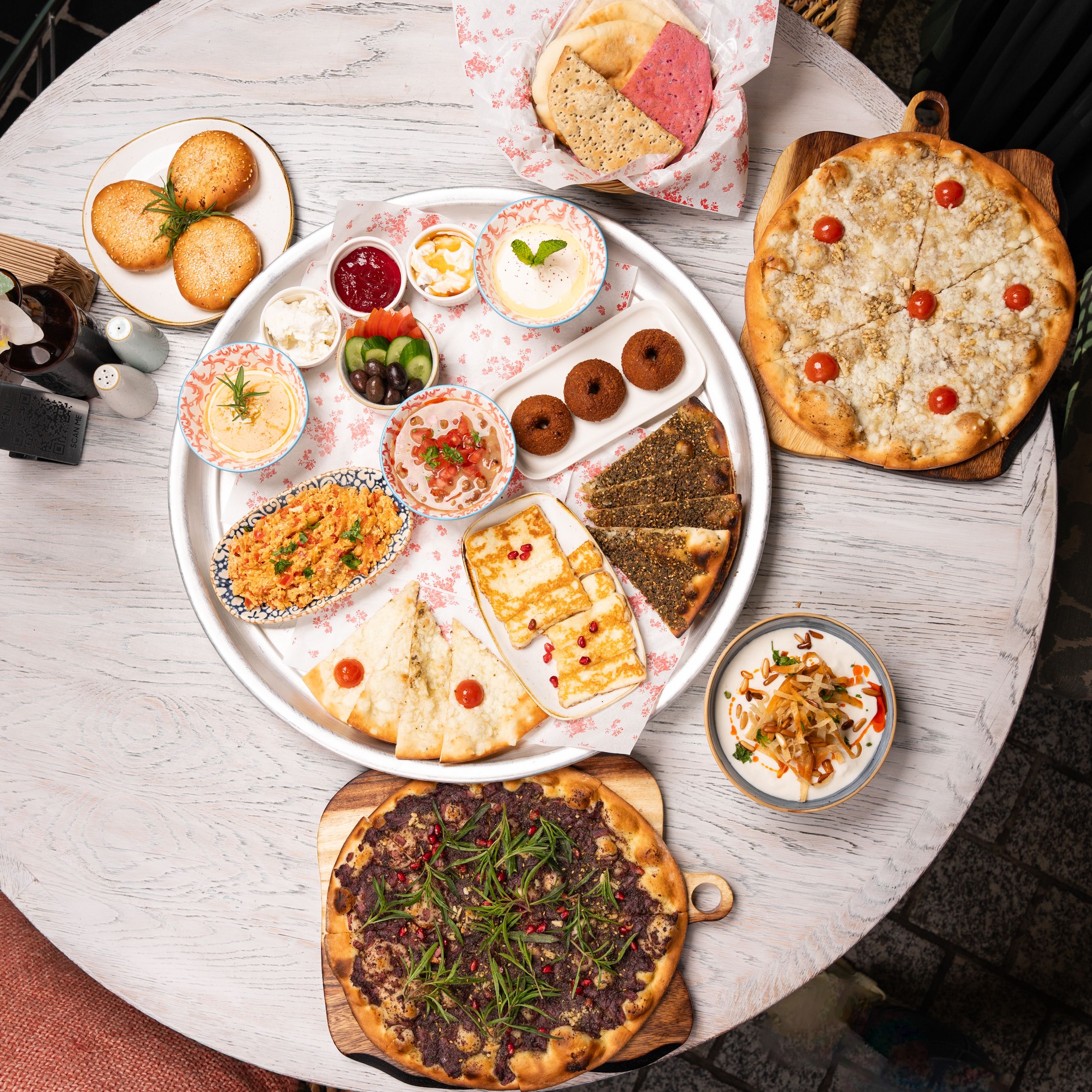 An overhead view of a diverse Middle Eastern meal spread on a round table.
