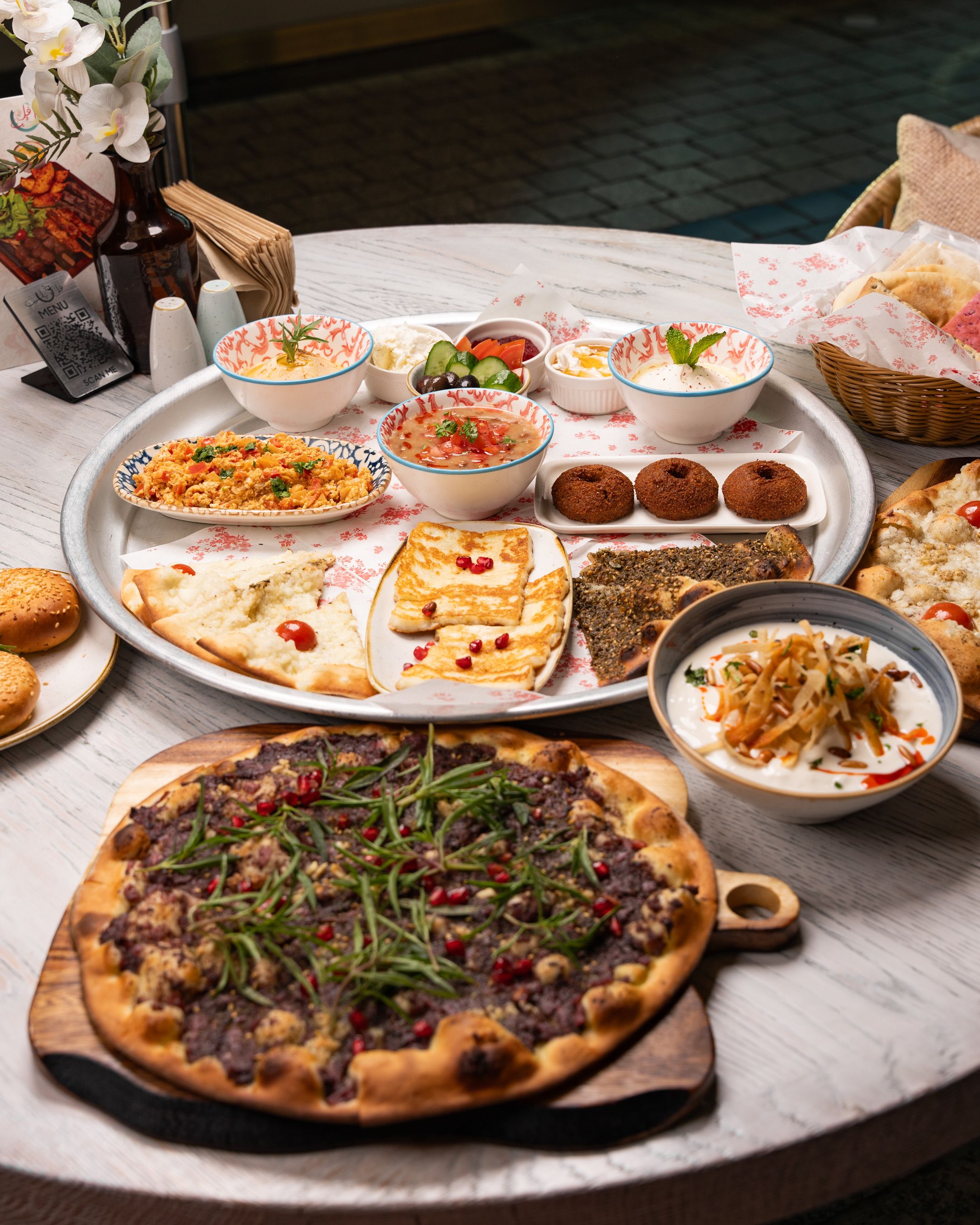Various Middle Eastern spices and harissa paste arranged on a rustic wooden surface