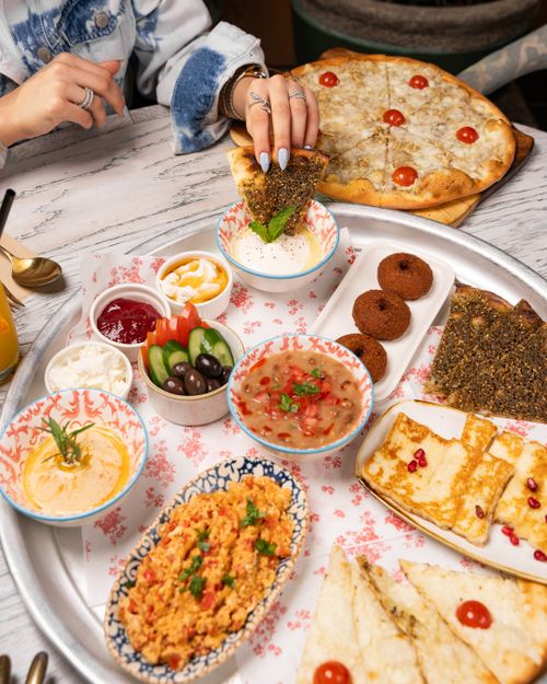 Free A diverse spread of Middle Eastern food featuring flatbread, dips, and falafel on a serving tray. Stock Photo