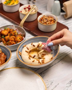 Middle Eastern cuisine with hummus and assorted dips, captured in a cozy setting.
